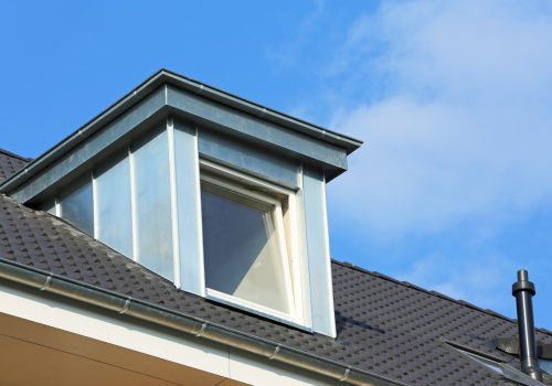 Dachgaube aus Metall mit geöffnetem Dachfenster auf dunklem Dach