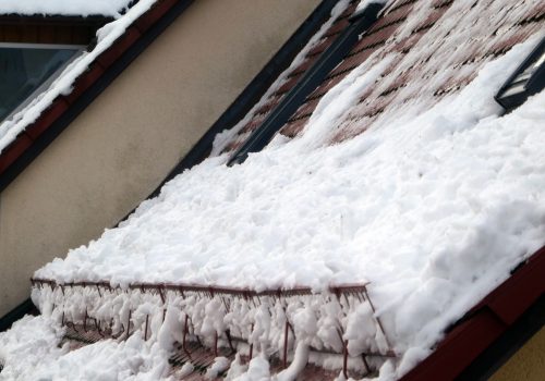 Schnee auf einem Dach wird von einem Schneefanggitter zurückgehalten